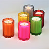 Colorful glass candle jars with single lit cotton wick