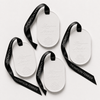 Four white oval perfumed ceramics with black ribbon handles printed with the Thompson Ferrier brand name, arranged on a light gray background.