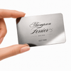 Thompson Ferrier mirror-finish titanium gift card with black logo held between two fingers.